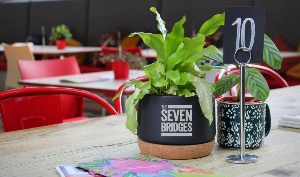 A table at The Seven Bridges with plant pot and mug